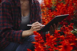 mujer agricultora de tecnología agrícola que sostiene tableta o tecnología de tableta para investigar sobre datos de análisis de problemas agrícolas e icono visual. foto