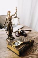 Justice and law concept.Male judge in a courtroom with the gavel, working with, computer and docking keyboard, eyeglasses, on table in morning light photo