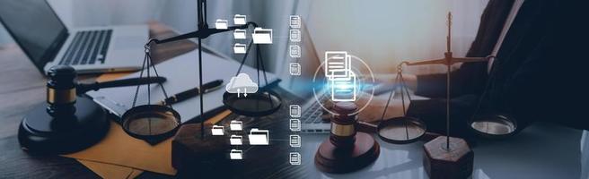 Justice and law concept.Male judge in a courtroom with the gavel, working with, computer and docking keyboard, eyeglasses, on table in morning light photo