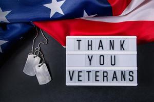 día conmemorativo en estados unidos. gracias a los veteranos. placas de identificación militares y bandera americana. concepto de celebración. foto