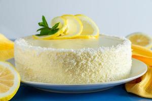 Lemon cake with coconut flakes and white cream, vanilla holiday dessert. photo