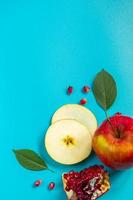 Honey, apples and pomegranates on blue background. Happy Rosh Hashanah. Jewish traditional religious holiday. photo