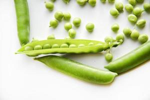 Pods of fresh green peas and green scattered peas. photo