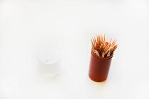 Wooden toothpicks and a pack of toothpicks on a white background photo