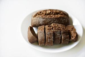 Rye bread from a hypermarket on a white plate. Delicious and beautiful bread macrophoto. photo