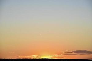 A clear evening sunset with blue and yellow reflections. Beautiful clear sunset. photo