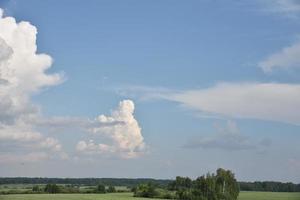 nubes tormentosas en un día de verano y un camino en el campo. una tormenta en un día brillante. foto