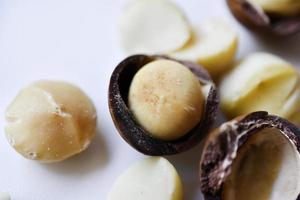 Whole nut and Macadamia kernel on a white background. Delicious whole nuts. photo