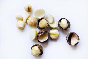 Whole nut and Macadamia kernel on a white background. Delicious whole nuts. photo