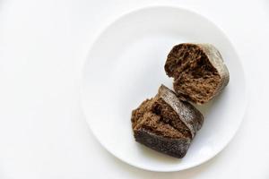 Rye bread from a hypermarket on a white plate. Delicious and beautiful bread macrophoto. photo