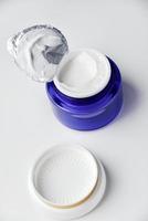 A jar of face cream on a white background. Night cream and hand close-up. photo