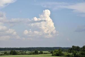 Thunderclouds on a summer day and a road in the countryside. A thunderstorm on a bright day. photo