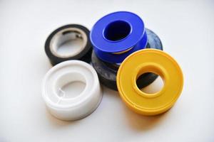 Rolls of duct tape and household putty on a white background. Insulating tape for dielectric processing, installation, repair. photo
