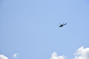 A white Mi-8 helicopter in the daytime sky. A flying cargo helicopter. photo