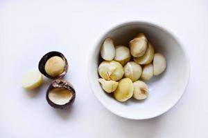 Whole nut and Macadamia kernel on a white background. Delicious whole nuts. photo