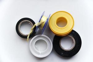 Rolls of duct tape and household putty on a white background. Insulating tape for dielectric processing, installation, repair. photo