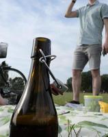 picnic en el parque - botella de cerveza con gente en el fondo foto