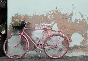 bicicleta rosa vintage apoyada contra una pared en la habana, cuba foto