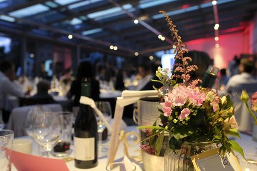 Evening event with flowers and wine bottles on the tables photo