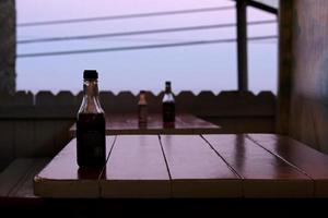 Hot sauces on the tables on an empty restaurant terrace during nightfall photo