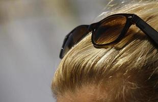 Close-up of blond woman with sunglasses in her hair photo