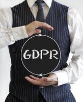 hombre sosteniendo un cartel con el acrónimo gdpr - reglamento general de protección de datos - escrito en él foto