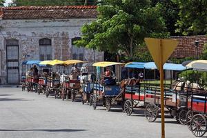 Havana, Cuba - July 2, 2019 - A row of horse wagons waiting for tourists in Havana, Cuba. photo