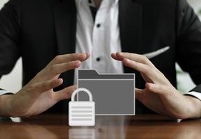 Businessman protecting a secured folder with his hands photo