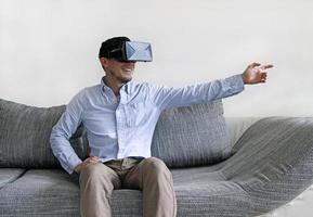 hombre con gafas de realidad virtual apunta hacia la derecha con el brazo foto