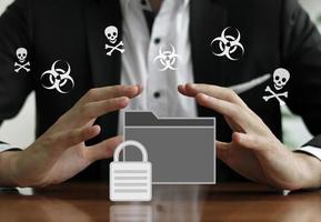 Businessman protecting a secured folder with his hands photo