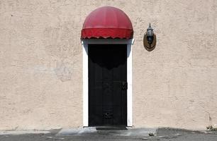 Metal door with little red roof on a sunny day photo