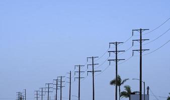 Row of power poles against a blue sky during a road trip photo