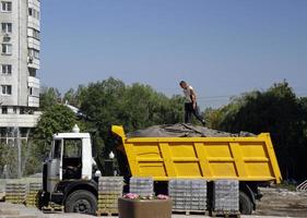 Almaty, Kazakhstan - August 23, 2019 - Worker on top of a truck at a construction site in Almaty, Kazakhstan. photo