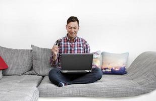 Smiling man with credit card and smartphone - mobile shopping - payment - banking photo