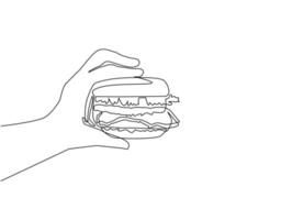 Single continuous line drawing hand holding burger. Hamburger. Delicious fast food. Cutlet with vegetables in bun with sesame seeds. Hand holding hamburger. Dynamic one line draw graphic design vector