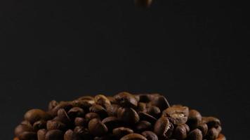 câmera lenta de grãos de café torrados caindo. sementes de café orgânico. video