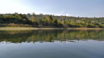 vista de barco navegando e movendo-se no grande rio com floresta tropical de natureza video