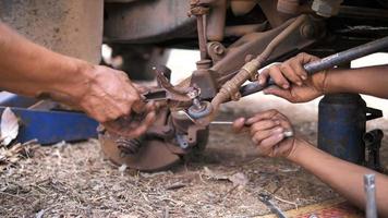 Hands of mechanic welding for repair the truck wishbone control arm of front wheel