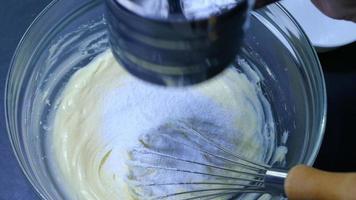 le persone preparano la miscelazione della crema di burro bianco nella cucina di casa per fare i biscotti, usando una macchina da cucina elettrica video