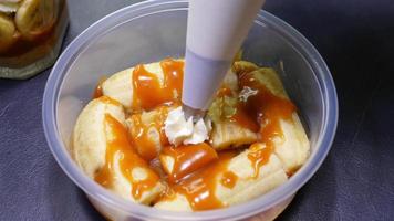 Closeup lady is making banoffee, putting whipped cream on top, homemade bakery concept video