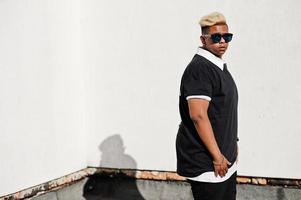 Stylish arabian muslim boy with originally hair and sunglasses posed on streets at roof. photo