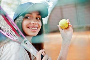 Young sporty girl player with tennis racket on tennis court. photo