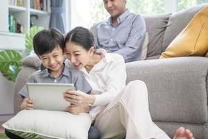 happy asian family spending time together on sofa in living room. photo