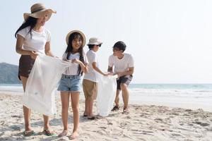 familia asiática caminando en la playa con niños felices vacaciones concepto foto