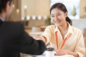 Portrait young Asian woman interviewer and interviewee shaking hands for a job interview .Business people handshake in modern office. Greeting deal concept photo