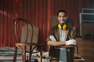 Young Asian man Carpenter working in woodcraft carpentry workshop. photo