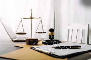 Justice and law concept.Male judge in a courtroom with the gavel, working with, computer and docking keyboard, eyeglasses, on table in morning light photo