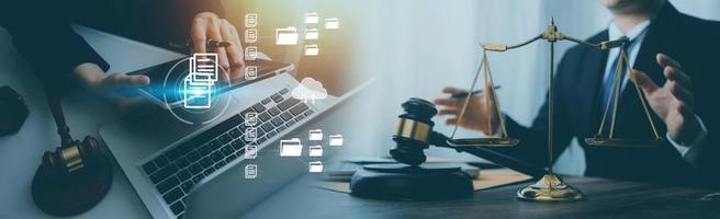 Justice and law concept.Male judge in a courtroom with the gavel, working with, computer and docking keyboard, eyeglasses, on table in morning light photo