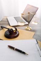 Justice and law concept.Male judge in a courtroom with the gavel, working with, computer and docking keyboard, eyeglasses, on table in morning light photo