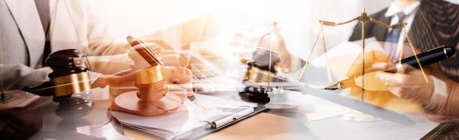 Justice and law concept.Male judge in a courtroom with the gavel, working with, computer and docking keyboard, eyeglasses, on table in morning light photo